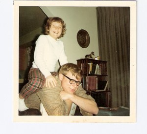 Carolyn on her big brother's shoulders, probably watching westerns and pretending to be a cowboy.