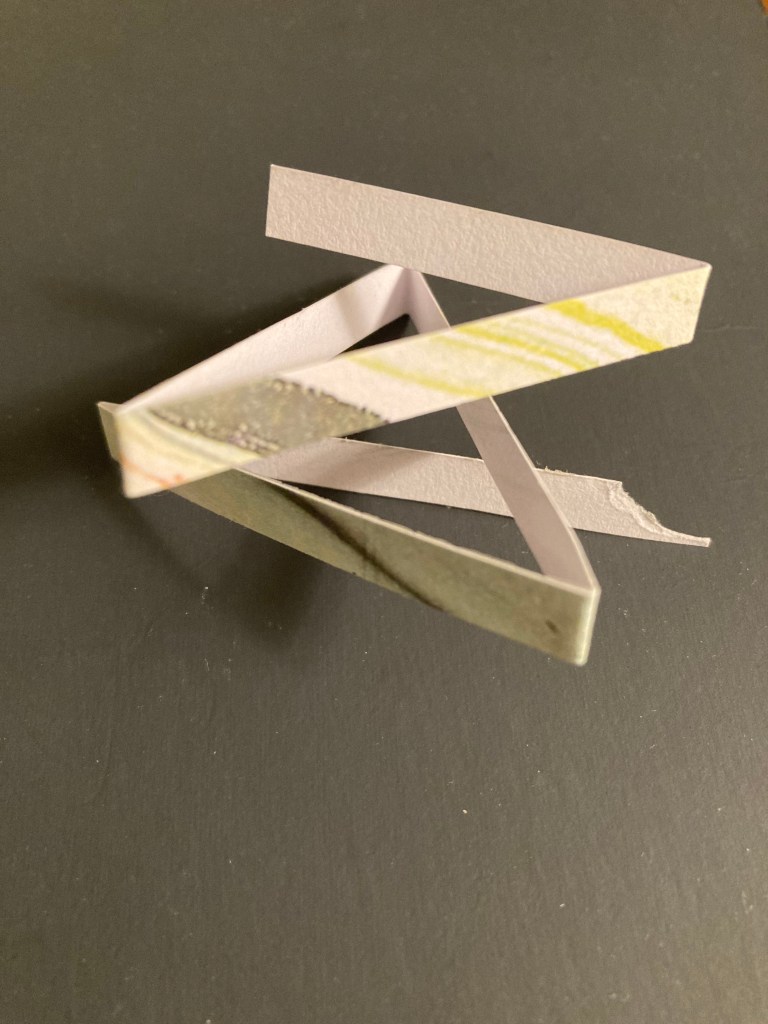 Three photos of a strip of paper from different perspectives, the last looks like a star.